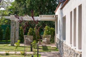 a patio with wicker chairs and an archway at Alexandra Beach Spa Resort in Potos
