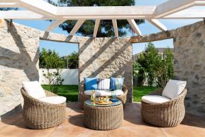 a patio with wicker chairs and a table at Alexandra Beach Spa Resort in Potos
