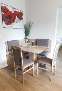 a wooden table with two chairs and a wooden table with at Komfort Ferienwohnungen Zwenkauer See in Zwenkau