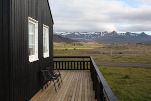 a deck with a chair on the side of a house at Gíslaholt in Borgarnes