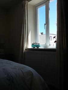 a bedroom window with a toy car sitting on a window sill at Harrington Flats in Newquay