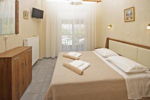 a bedroom with a large bed with towels on it at FunBeach Rooms in Neos Marmaras