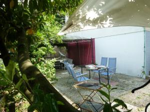 a patio with chairs and a table and a tent at La Malle - la suite in Schiltigheim