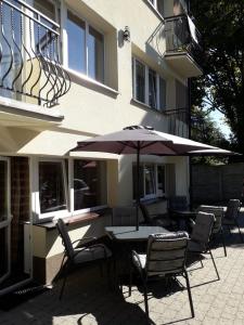 a table and chairs with an umbrella in front of a building at MAXI - Mielenko in Mielenko