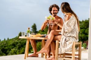 a man and woman sitting at a table on the beach at SECRET HILL in Athani
