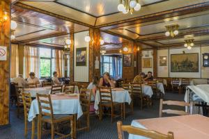 a restaurant with tables and people sitting at tables at Spa & wellness Villa Garetov Konak in Prolomska Banja