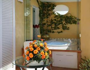 a table with a bouquet of orange flowers in front of a mirror at Hotel Marincanto in Positano