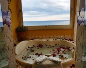 a bathroom with a bath tub with a window at Hotel Marincanto in Positano