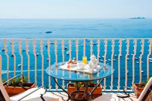 a table on a balcony with a view of the water at Hotel Marincanto in Positano