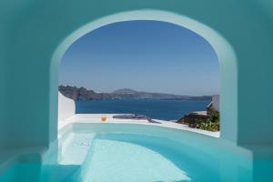 a swimming pool with a view of the ocean at Chelidonia Luxury Suites in Oia