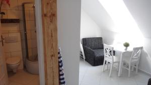 a bathroom with a table and a chair and a toilet at Gaski Na Fali in Gąski +60 photos