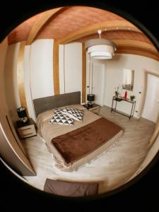 a bedroom with a large bed and a round mirror at Amaranto Bed & Breakfast in Cavour