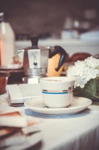 una taza de café en un plato en una mesa en Amaranto Bed & Breakfast, en Cavour