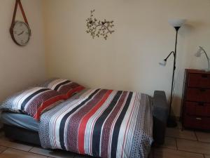 a bedroom with a bed and a clock on the wall at Ferienwohnung Reuter in Niederzissen