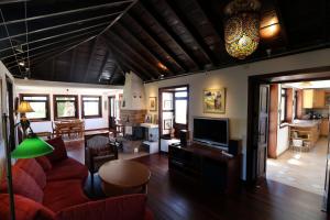 a living room with a red couch and a tv at Villa Escondida in Breña Baja
