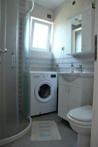 a bathroom with a washing machine and a sink at Ivezić in Njivice