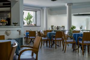 a dining room with blue tables and chairs at Hotel Panoramic in Giardini Naxos