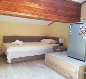 a bedroom with a bed and a refrigerator at Часовника in Tryavna