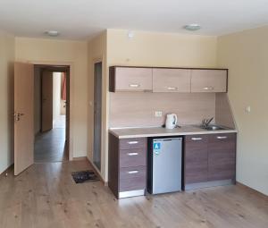 an empty kitchen with a sink and a refrigerator at Часовника in Tryavna