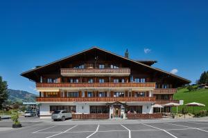 a large wooden building with a parking lot at Hotel Alphorn in Gstaad
