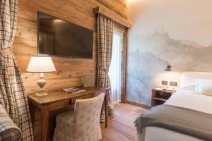 a bedroom with a bed and a television at Auberge De La Maison in Courmayeur