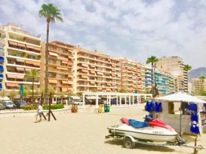 - un bateau sur la plage à côté d'un hôtel dans l'établissement Apartamento Don Miguel Playa, à Fuengirola