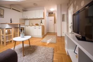 a kitchen and living room with a table and a television at Stella Modern Apartment in Novi Sad