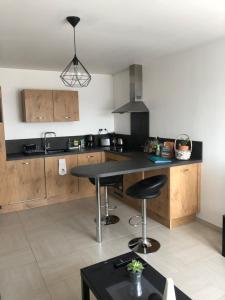 a kitchen with a black counter and a table at Appart. sur Caen avec Garage et Wifi. in Caen
