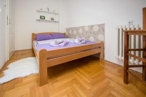 a bed in a room with a wooden floor at Stella Modern Apartment in Novi Sad