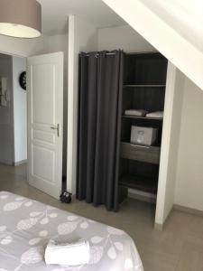 a bedroom with a bed and a closet with curtains at Appart. sur Caen avec Garage et Wifi. in Caen