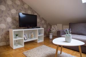 a living room with a tv on a white cabinet at Stella Modern Apartment in Novi Sad