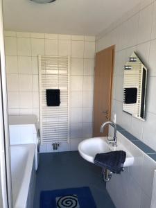 ein Badezimmer mit einer Badewanne, einem Waschbecken und einer Badewanne in der Unterkunft Schwarzwaldidylle in Waldachtal