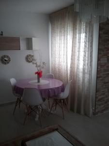 a purple table with chairs and a vase of flowers at Ático vacacional in Muros