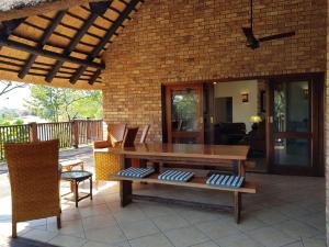 an outdoor patio with a wooden table and chairs at Kruger Park Lodge ITR01 3 Bedroom in Hazyview