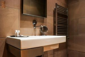 a bathroom with a white sink and a mirror at Villa Zawaia B&B in Lagos