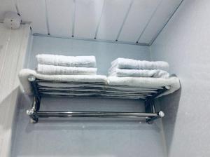 a towel rack with towels on it in a bathroom at THE LION'S DEN ON ROYAL STREET in Gourock