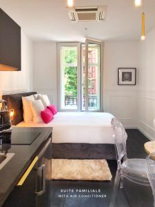 ein weißes Schlafzimmer mit einem Bett und einem Fenster in der Unterkunft LIFE CATHEDRALE City-Center Place Gutenberg in Straßburg