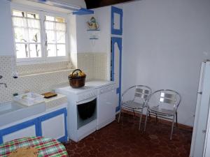 a kitchen with a stove and two chairs in it at L'Estagnol in Le Castellet