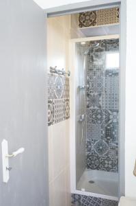 baño con ducha y puerta de cristal en gite du tourneur en Saint-Cirq-Lapopie