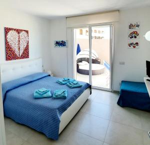 a bedroom with a bed with blue towels on it at Appartamento delfini sul mare in Golfo Aranci