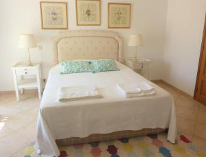 a bedroom with a large white bed with two tables at Santos Villa in Quinta do Lago in Quinta do Lago +65 photos