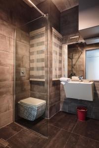 een badkamer met een wastafel, een toilet en een douche bij Talbot & Bons Studio Flat in Gudja