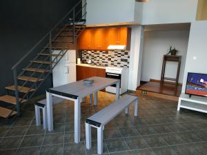 a table and bench in a room with a staircase at Marilia apartment in Agios Nikolaos