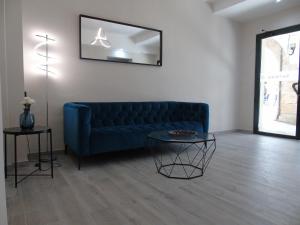 a living room with a blue couch and a table at Casa San Nicolás in Portomarin