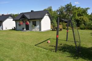 a house with a basketball hoop in a yard at Domki "Bociania Ostoja" in Mikołajki