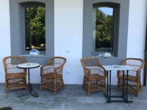 a group of wicker chairs and tables and windows at Villa Marta Casa de Indianos Passive House in Villanueva de Ardisana