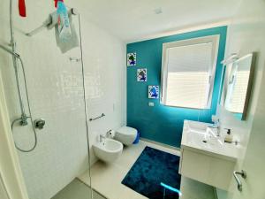 a bathroom with a shower and a toilet and a sink at Appartamento delfini sul mare in Golfo Aranci +53 photos
