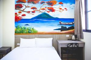 台東市的住宿－愛町堡民宿，卧室配有一张床,墙上挂有绘画作品