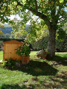 a wooden box with flowers in it next to a tree at Le Jas de Verdolier in Sault-de-Vaucluse