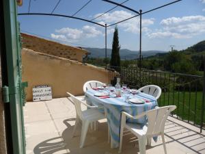 a table with white chairs and a blue table cloth at Le Jas de Verdolier in Sault-de-Vaucluse
